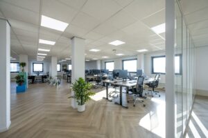 Ruim en licht kantoorpand aan de Joan Muyskenweg met moderne werkplekken, grote ramen en houten vloer.